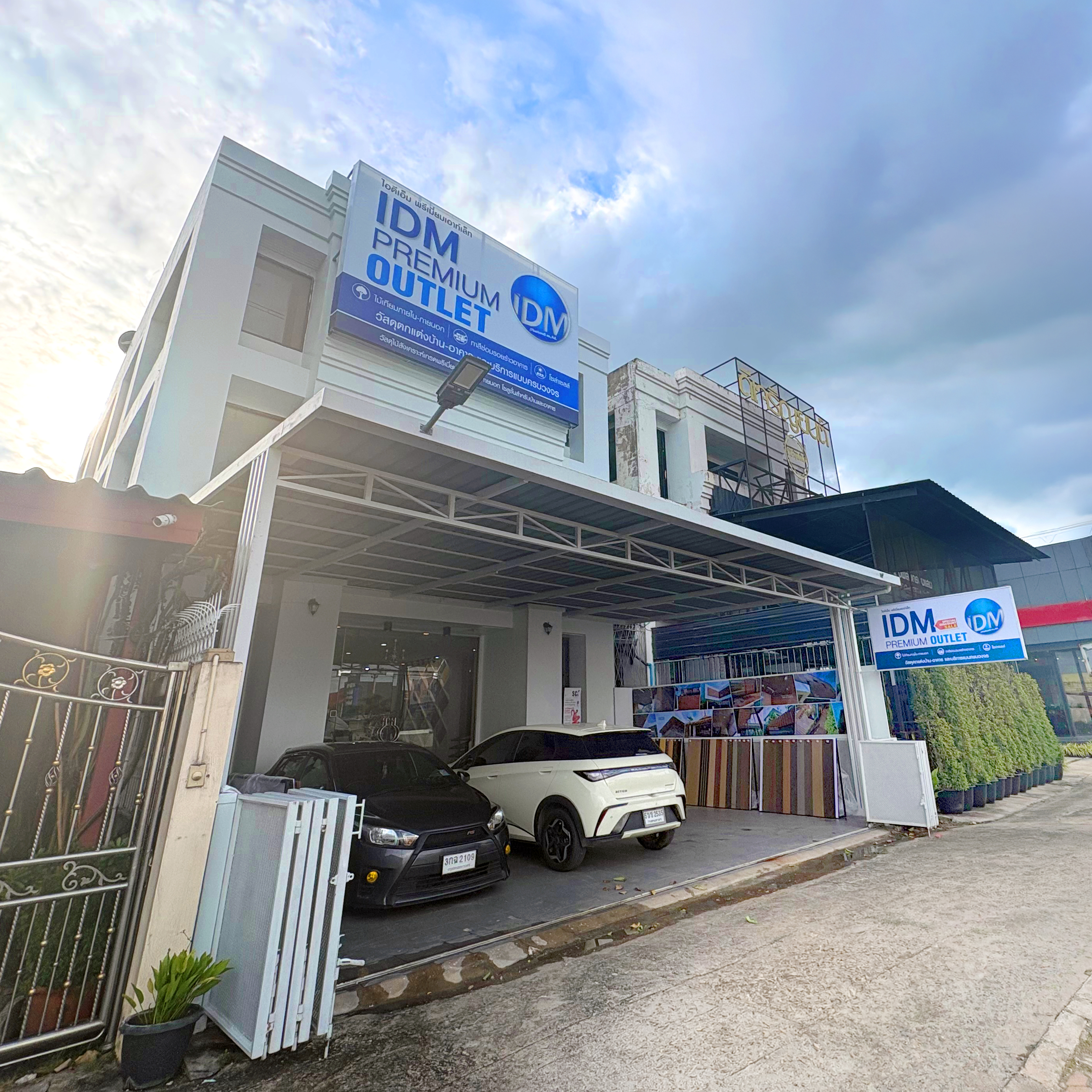 ด้านหน้าร้าน IDM Premium Outlet พร้อมตัวอย่างไม้เทียมหลากสีวางโชว์หน้าร้าน